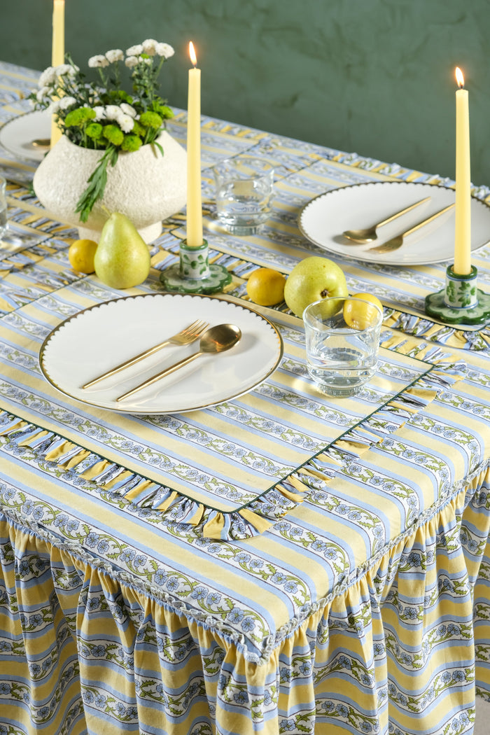 Provence Butter Yellow Ruffled Cotton Tablecloth — Provence cloth at a table with separate flowers and candles; Inner Child