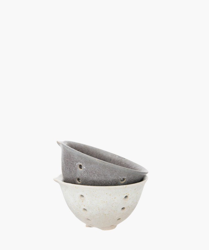 Two stacked ceramic bowls with small holes. The bottom bowl is light-colored with speckles, and the top bowl is a textured gray. Simple and artistic. | Wildwood Home Co.