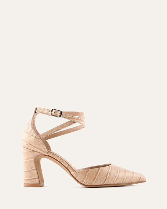 Beige high-heeled shoe with an ankle strap on a light beige background