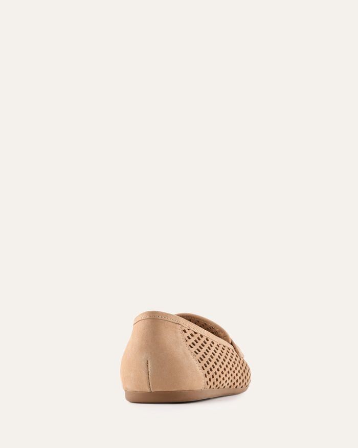 Beige slip-on shoe with perforated design on a light beige background