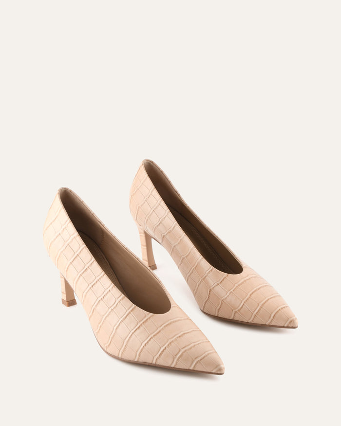 Pair of beige high-heeled shoes with a textured pattern on a white background