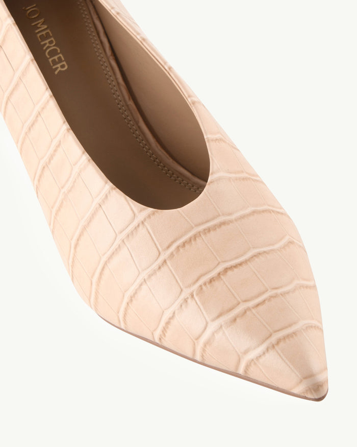 Beige pointed-toe shoe with crocodile texture on a white background