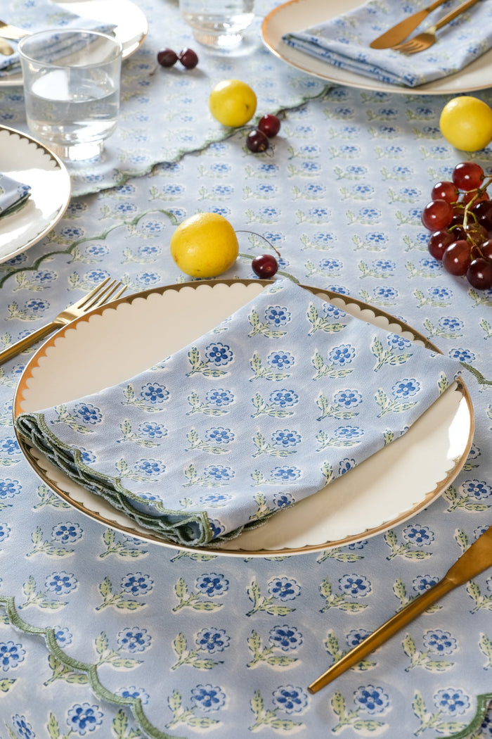 Mona Blue Scalloped Cotton Napkins — folded napkin at a setting with separate plate and flatware; Inner Child