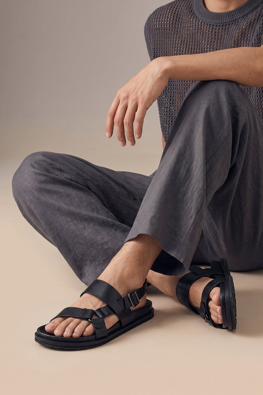 Model wearing Saxon Black leather ring strap sandals for men by Oswin Hyde with sleek design and comfortable fit