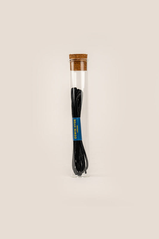 Black 2mm round waxed cotton shoe laces by Oswin Hyde, polished with natural beeswax and packaged in a luxury glass tube.