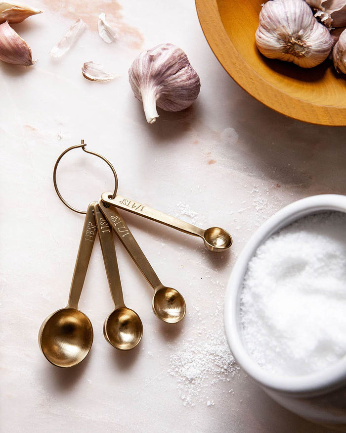Stowe Measuring Spoons — gold measuring spoons beside garlic and salt; Farmhouse Pottery