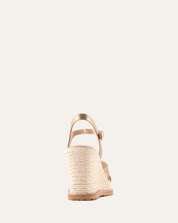 Beige wedge sandal with braided sole on a white background