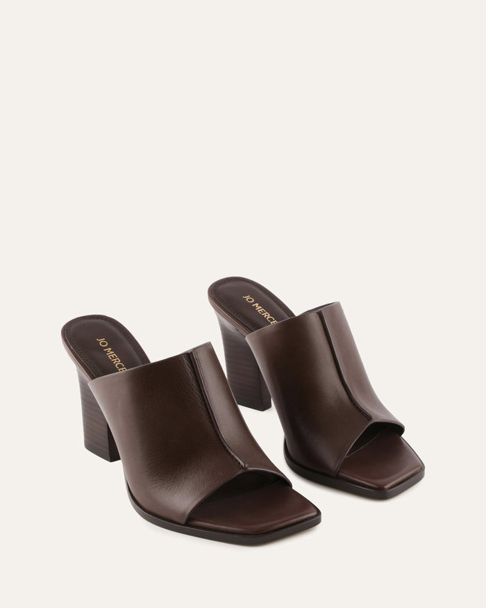 Pair of brown open-toe high-heeled shoes on a white background