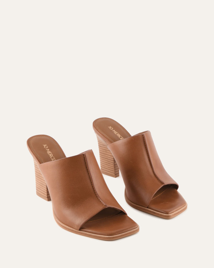 Pair of brown open-toe heeled sandals on a white background